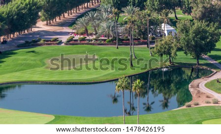 Landscape of green golf course with trees and lakes aerial timelapse. Dubai, UAE. Top view from Greens district near Dubai marina