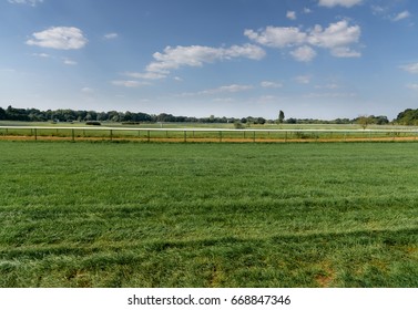 Landscape Of Green Grass Hippodrome With Blue Sky. Turf Racecourse In Germany, Magdeburg. Horse Track. Green Grass Field. Background. View From Below