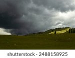 Landscape of Heavy Cloud on field. Green hills and stormy sky. Bad weather day outdoor. Beautiful dramatic nature shot with copy space. Natural wallpaper background