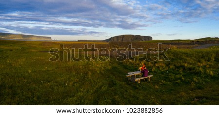 Landscape of iceland, two women sitting by the touristic table