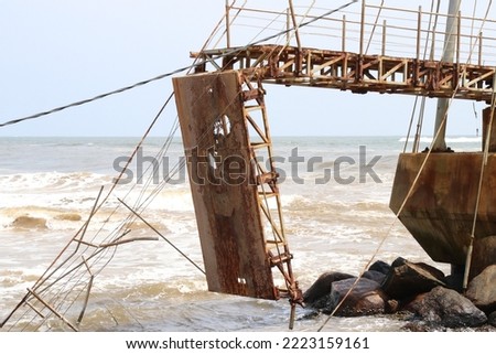 The landscape image of the corroded and eroded structure of a  Collapsed abandoned vintage iron suspension bridge.