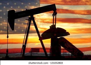 Landscape image of a oil well pumpjack wiith an early morning golden sunrise and American USA red White and Blue Flag background. - Powered by Shutterstock