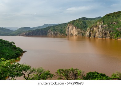Landscape including calm brown water of Lake Nyos, famous for CO2 eruption with many deaths, Ring Road, Cameroon