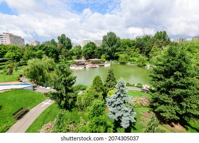 Landscape With Lake And Vivid Green Trees In Drumul Taberei Park (Parcul Drumul Taberei) Also Known As Moghioros Park, In Bucharest, Romania, In A Cloudy Summer Day