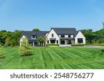 Landscape with large modern country house. Landscape design, mowed lawn and blue sky.