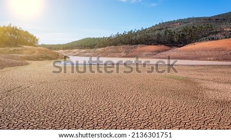 Landscape of low water and dry land in advance, severe drought in the reservoir of Portugal. Ecological disaster, soil dehydration. desert, drought,
