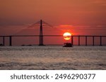 Landscape of the Manaus bridge over the Rio Negro at sunset with boats