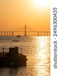 Landscape of Manaus bridge over the Rio Negro at sunset with boat going by and a pier on the foreground