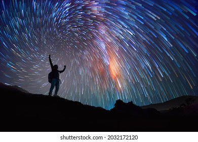 Landscape with Milky Way. Night sky with stars and silhouette of a standing happy man on the mountain, Success or winner, leader concept.  