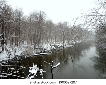 Landscape With Miserable Winter Weather. Tree-lined River, Still Unfrozen, Snow Mixed With Rain. All Grey, No People. Taken In February In Greater Lansing, Michigan.