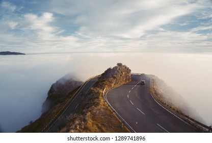 Landscape misty panorama. Fantastic dreamy sunrise on rocky mountains with view into misty valley below. Foggy clouds above forrest. View below to fairy landscape. Foggy forest hillsBeautiful sunset 