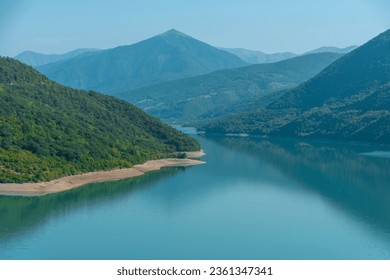 Landscape with a mountain lake in a blue haze in the morning. The screensaver for the desktop of the computer.