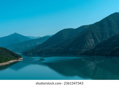Landscape with a mountain lake in a blue haze in the morning. The screensaver for the desktop of the computer.