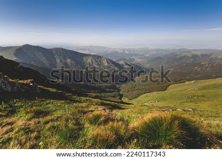 Landscape with mountain range, green hills and rocks under blue sky in Old Mountain National park, nature preserve between Serbia and Bulgaria. Stara Planina hillside on sunny summer day.