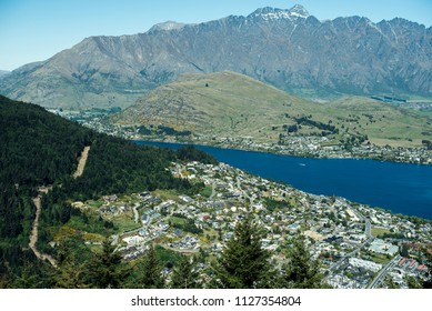 Landscape of mountains, a blue lake and some city from above