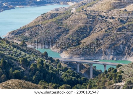 Landscape of mountains, waters of a swamp and a truck driving along a viaduct, Rules dam.