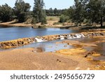 landscape with natural waterfall on the Rio Tinto ,Red River,as it passes through Coria del Rio, in Huelva, Spain.