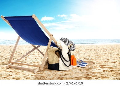 landscape of ocean and beach with chair bag and hat 