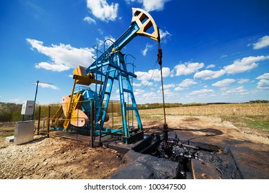 Landscape With Oil Pump Under Blue Sky With Clouds In A Sunny Day