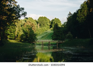 Landscape with old wooden bridge over the river surrounded by beautiful forest