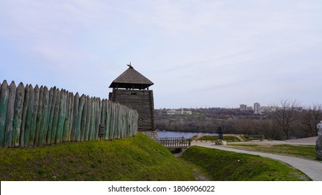 Landscape on a historic temple made of wood in Europe. The fortress is fenced with a wooden palisade against the background of the sky and the river. Thick beams with a sharp top. - Shutterstock ID 1806906022