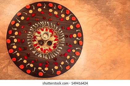 Landscape Of An Overhead Capture Of A Floral Display During Hindu Festivals And Auspicious Family Occasions Such As Divali, Weddings, Parties And New Years Eve Centered With A Brass Tea Set 