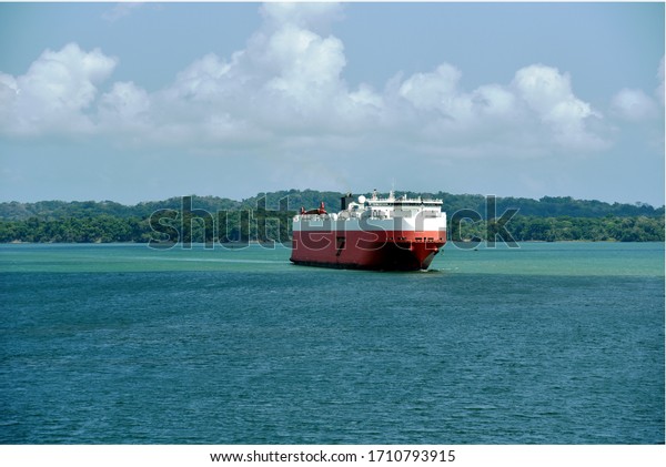 Landscape of the\
Panama Canal with car carrier ship sailing through Gatun Lake, on\
her international trade route.\
