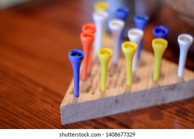 Landscape Photo Of A Multicoloured Triangular Peg Board Game On A Wood Table.