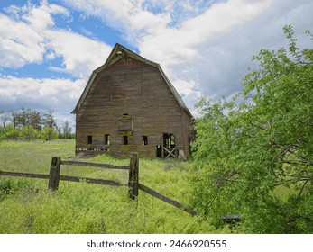 A landscape photo of an old abandoned barn under a dramatic cloudy sky in north Idaho. - Powered by Shutterstock