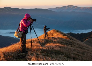 Landscape photographers with the tripods on the mountain top early in the morning. Creating exclusive photo content. Artists at work. - Powered by Shutterstock