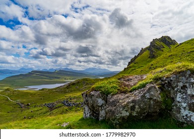 Landscape photography of Scottish Highlands from Isle of Skye with sea and Scottish mountains in the background under a cloudy sky with a rock in the first plan. - Shutterstock ID 1779982970