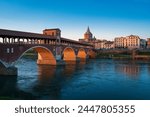 Landscape of Ponte Coperto (covered bridge) and Duomo di Pavia (Pavia Cathedral) in Pavia at sunset, Lombardy, italy.