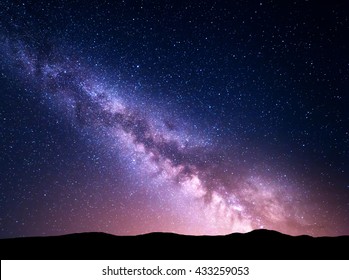 Landscape With Purple Milky Way And Red City Lights. Night Sky With Stars And Hills At Summer. Amazing Universe. Space Background. Beautiful Galaxy