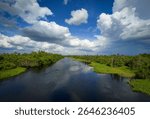 Landscape with river and clouds. Reflection of clouds on the water surface gives the image a sense of volume and depth of space.