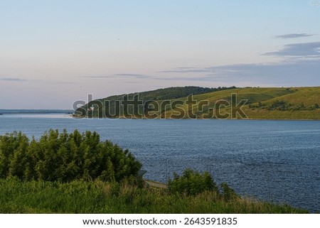 Landscape: the river flows between two green banks. High quality photo