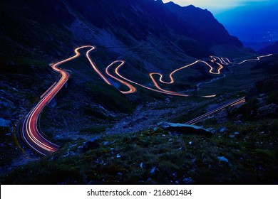 Landscape From The Rocky Fagaras Mountains In Romania In The Summer Evening With Transfagarasan Winding Road In The Distance