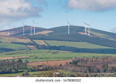 Landscape Of Rolling Hills In Ireland With Wind Turbine