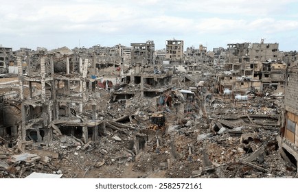 A landscape of rubble and ruins shows the devastating aftermath of the Israeli offensive, with destroyed buildings and debris covering the war-torn area.