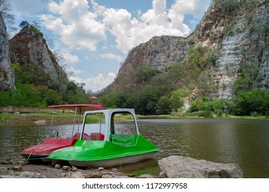 Landscape Scenery Of Limestone Mountain With The Cloud And Blue Sky In Background.Paddle Boat Parking In The Lake With Rocky Mountain In Background