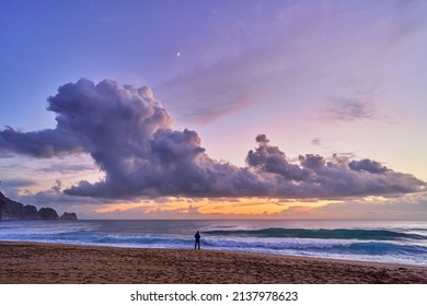 Landscape of scenic idyllic peaceful calm sky wallpaper with fluffy clouds and silhouette person standing alone at sea coast and sandy beach