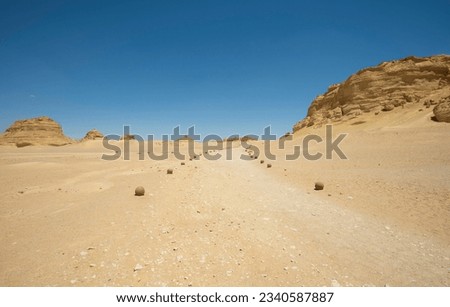 Landscape scenic view of desolate barren western desert in Egypt with footpath through geological mountain sandstone rock formations