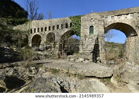 Landscape with scenic view of the medieval stone bridge. with the small Byzantine church dedicated to the Genesis of the Virgin a historic landmark of Karytaina in Arcadia, Greece. 