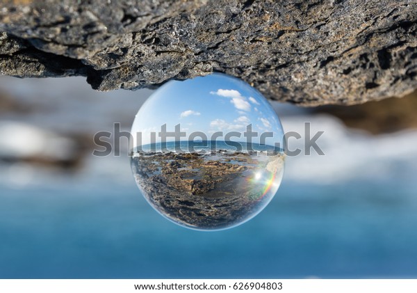 ガラス玉を通して見える海と岩の風景 の写真素材 今すぐ編集