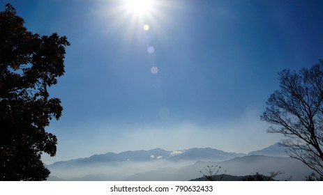 a landscape of the sun and mountain range