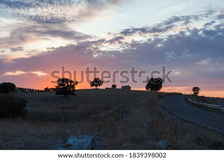 Landscape at sunset. Road going up a hill with a lonely house