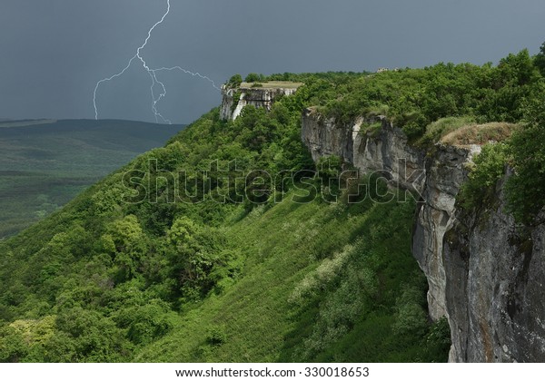 Landscape with thunderstorm in mountains. The\
approaching storm front over mountains. The dividing line of solar\
weather and stormy weather in\
Crimea.