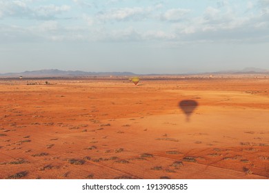 Landscape With Tiny Hot Air Ballon Flight In The Early Morning Desert In Morocco.