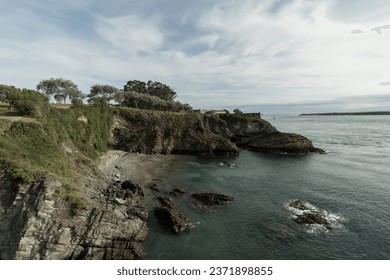 Landscape of a Tree-Covered Cliff Overlooking a Calm Sea - Powered by Shutterstock