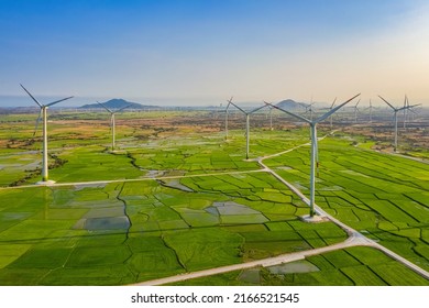 Landschaft mit Turbine Green Energy Electricity, Windmühle für die Stromerzeugung, Windturbinen, die Strom auf Reisfeldern in Phan Rang, Ninh Thuan, Vietnam erzeugen. Konzept für saubere Energie
