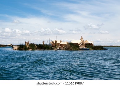 Landscape of the Uros floating islands in the magic blue colors of the Titicaca Lake with the Andes mountain range in the background.
